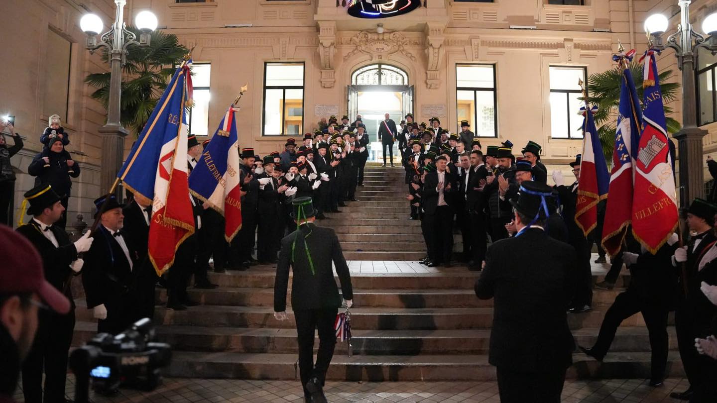 Sous une haie d'honneur des conscrits de sa classe, le président des 20 ans gravit les marches de l'Hôtel de Ville pour rejoindre le Maire afin de lui rendre les clefs de la ville