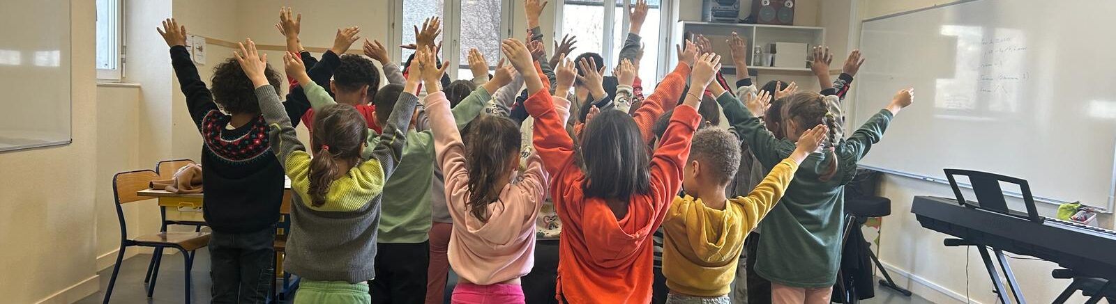 Des élèves de dos lèvent les mains