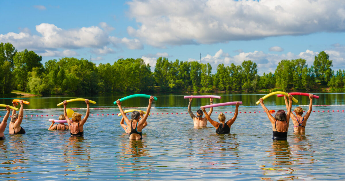Cours d'aquagym dans l'eau par un maitre nageurs et des sportifs.