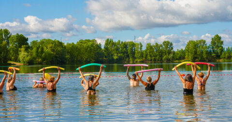 Cours d'aquagym dans l'eau par un maitre nageurs et des sportifs.